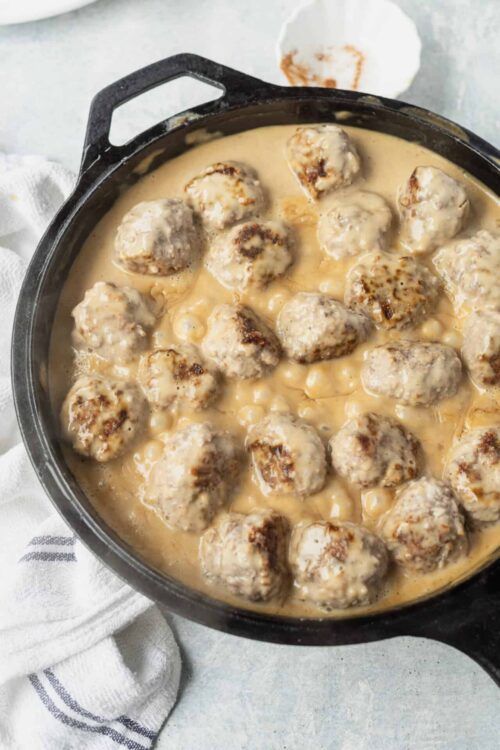 Savory meatballs in creamy gravy in cast iron skillet.