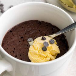Rich chocolate mug cake topped with vanilla ice cream and chocolate chips, perfect for quick dessert recipes.