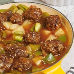 Savory meatball and vegetable stew in a yellow skillet, gluten-free comfort food.