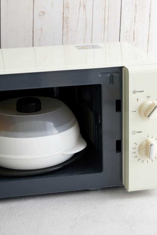 Toaster oven with a white ceramic dish inside, modern kitchen appliance for baking and heating food.