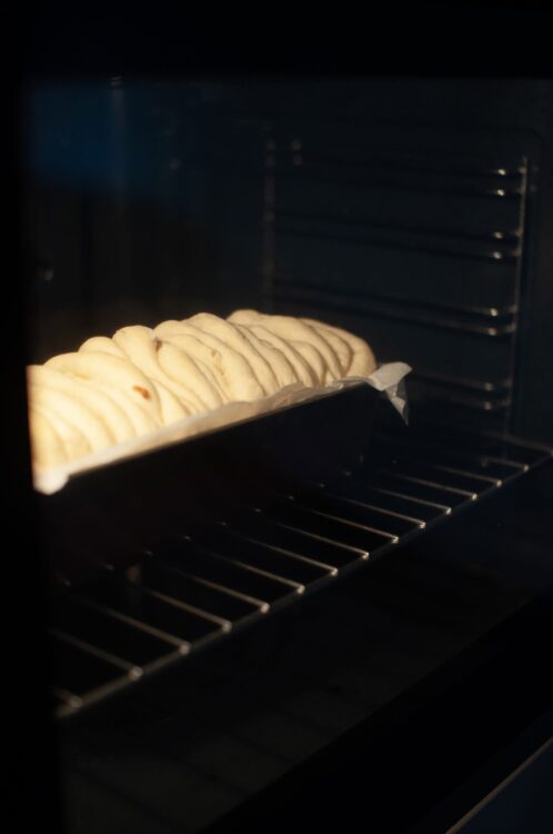 Golden baked bread dough rising in the oven, ready to be baked into fresh bread.