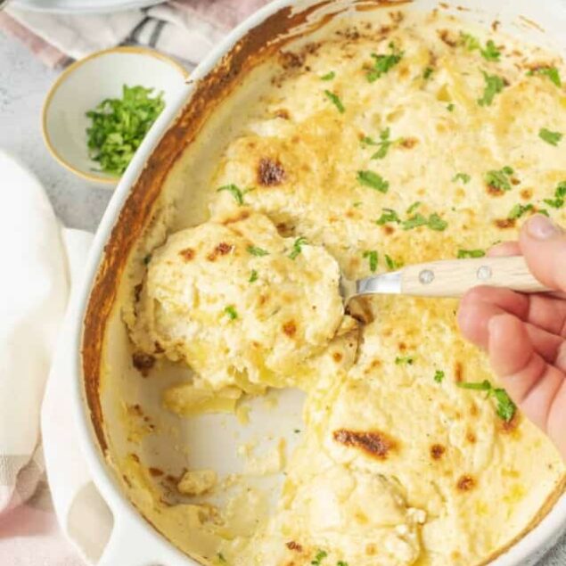 Creamy potato casserole baked to golden perfection, garnished with fresh herbs for added flavor.
