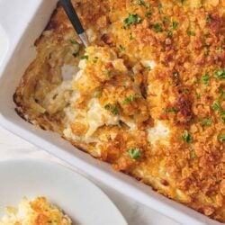 Creamy scalloped potato casserole with crispy breadcrumb topping, garnished with fresh parsley.