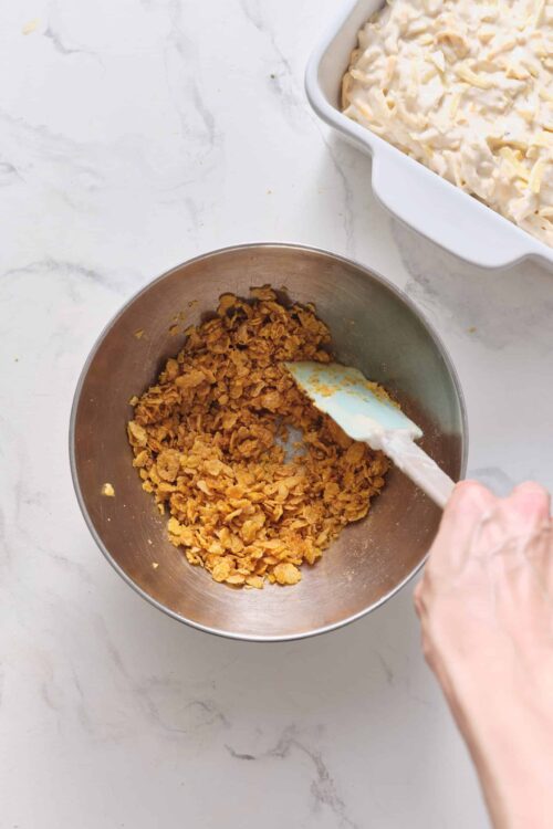 Golden graham cracker crust being prepared in a mixing bowl.