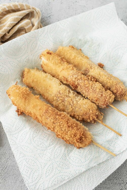 Crispy breaded fish sticks on a paper towel, ready to serve. Perfect for quick, homemade fish and chips with a crunchy coating.
