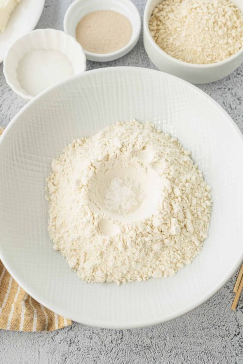 Flour and baking ingredients in white bowls for baking homemade bread or pastry.