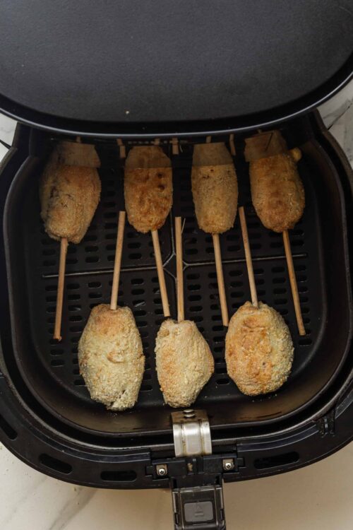 Crispy chicken cordon bleu in air fryer, breaded chicken breasts on skewers, baked in air fryer for crispy texture, homemade comfort food.