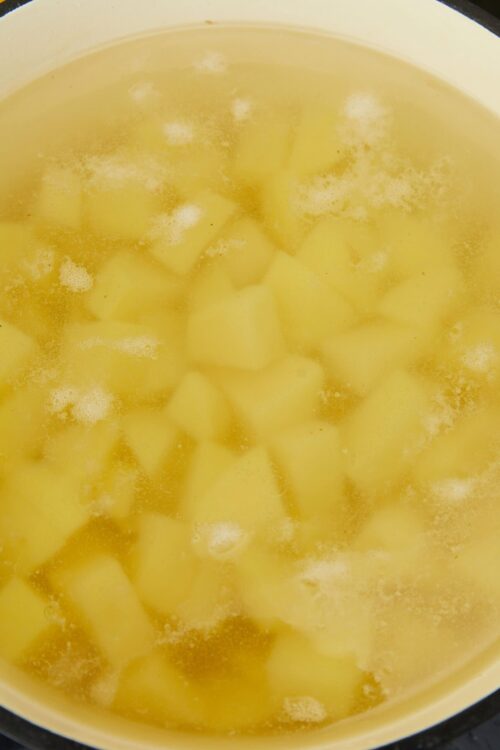 Diced potatoes boiling in a pot of water, ready for cooking or recipe preparation.