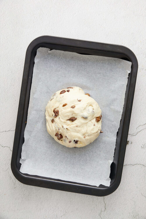 Creamy chocolate chip cookie dough on baking tray, ready for baking.