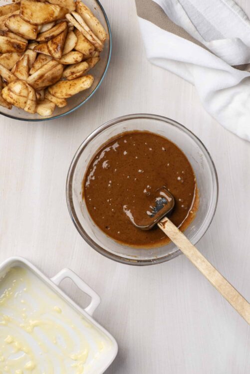 Rich homemade caramel sauce in a glass bowl topped with butter and cream ingredients. Perfect for desserts and baking.