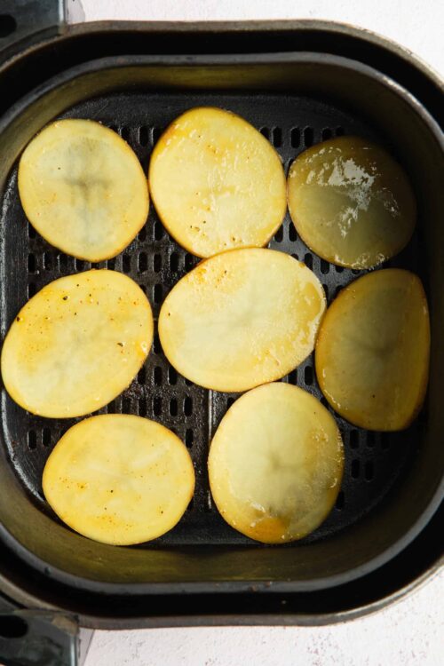 Golden roasted potato slices in air fryer.
