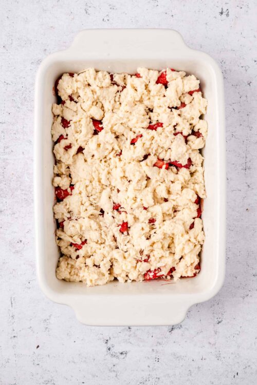 Fresh strawberry crumb cobbler ready to bake with a buttery crumb topping.