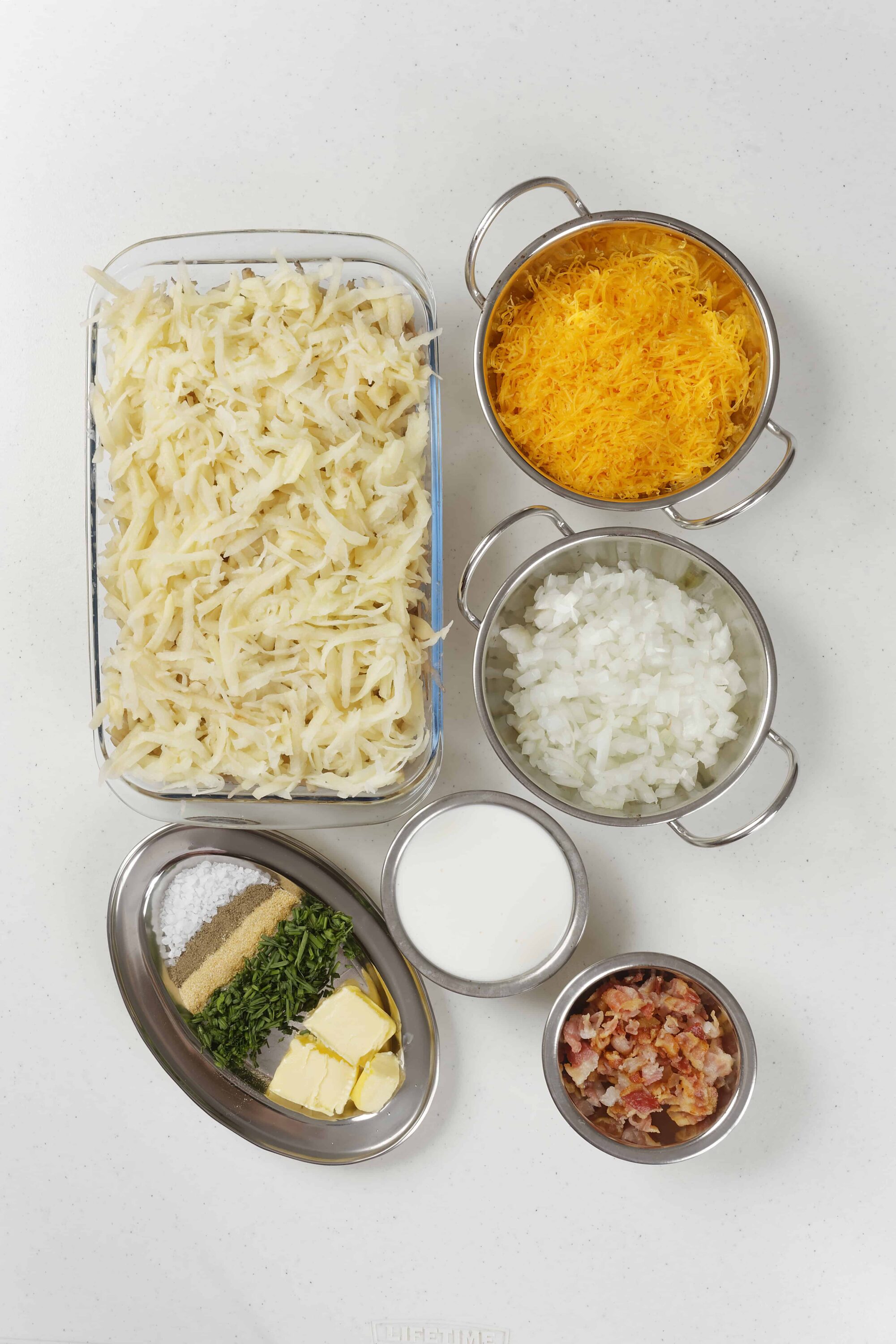 Cream cheese, shredded cheddar cheese, and diced onions for baked cheesy potato casserole.