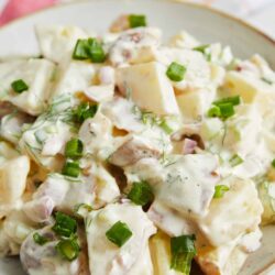 Creamy potato salad with chopped green onions and fresh herbs.