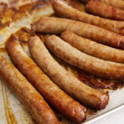 Golden cooked breakfast sausage links in a baking dish.