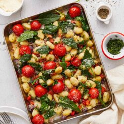 Fresh gnocchi with cherry tomatoes, spinach, and herbs in a baking dish inspired by Baked Bree.