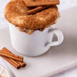 Creamy cinnamon spice hot cocoa topped with frothy whipped cream and cinnamon sticks, perfect for cozy winter mornings.