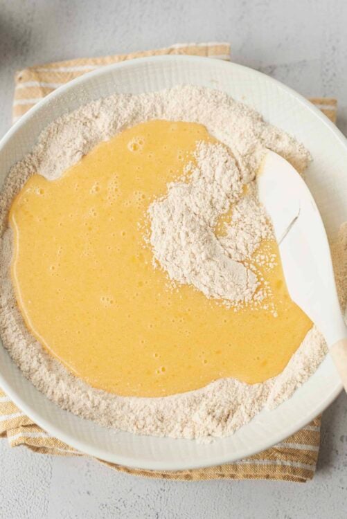 Flour and beaten eggs for baking on a white bowl at Baked Bree.