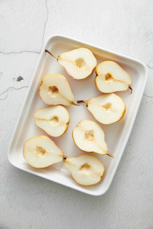 Fresh cut pears on a white serving dish for healthy snacking.