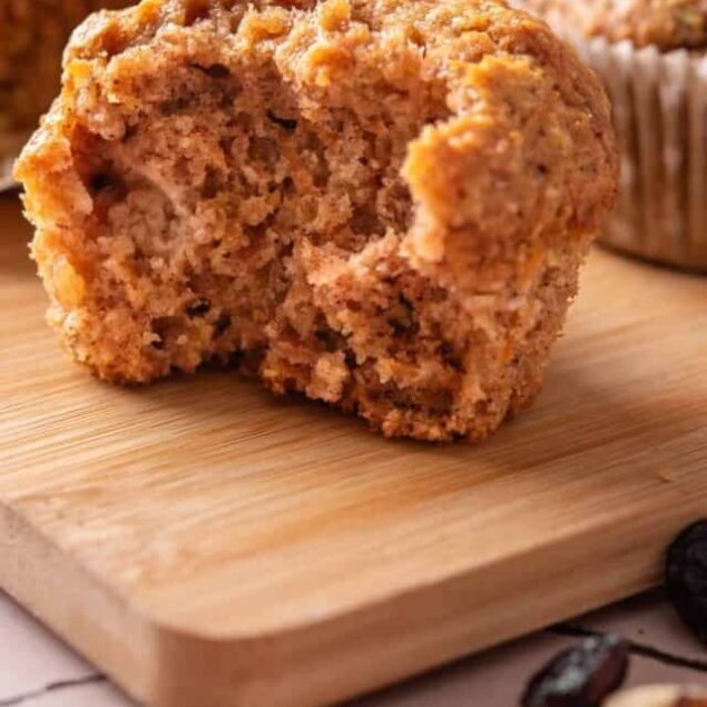Warm cinnamon muffin broken in half on a wooden cutting board. Freshly baked muffins with a golden-brown crust. Perfect for breakfast or snack.