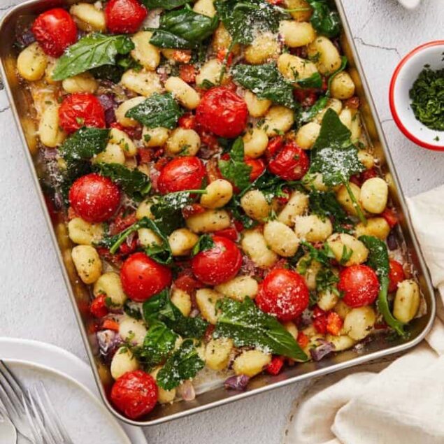Fresh gnocchi with cherry tomatoes, spinach, and herbs in a baking dish inspired by Baked Bree.