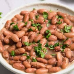 Savory bean chili topped with fresh cilantro in a white bowl.
