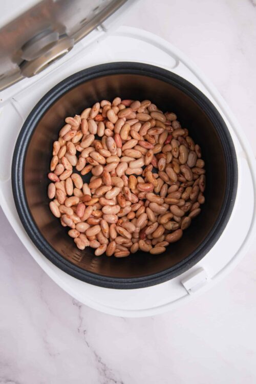 Cooked pinto beans in a slow cooker, ready for a delicious recipe, healthy vegetarian meal.