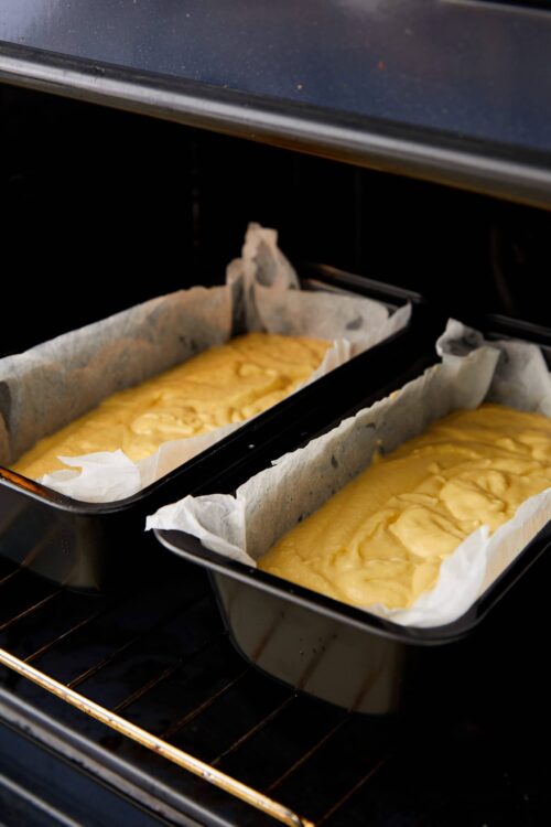 Baked cheesecake batter in oven pans for baking, parchment paper lined.