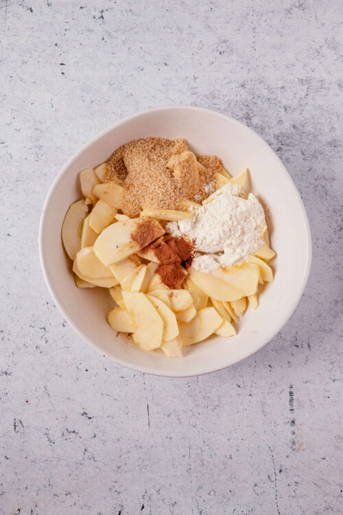 Creamy mashed potatoes with seasonings and flour in a white bowl for baking recipes.