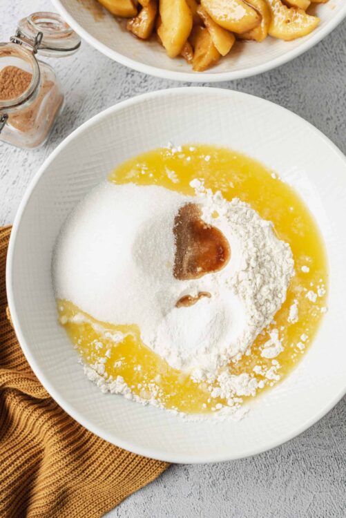 Flour, sugar, eggs, vanilla, and butter in a mixing bowl for baking.
