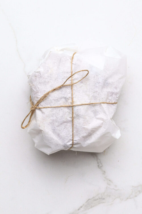 Crisp baked goods wrapped in white parchment paper and tied with twine, ready for delivery or gift.
