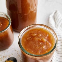 Sweet caramel apple butter in glass jars, homemade autumn spread.