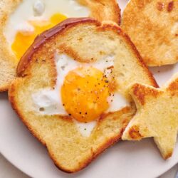 Soft toasted bread with baked eggs, perfect breakfast classic.