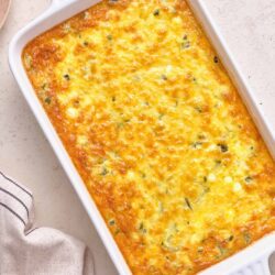 Creamy baked casserole with cheese and herbs in a white dish.