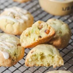 Fresh homemade apple cinnamon muffins with nuts and icing on a cooling rack.