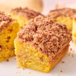 Buttermilk crumb cake with streusel topping on white cutting board.