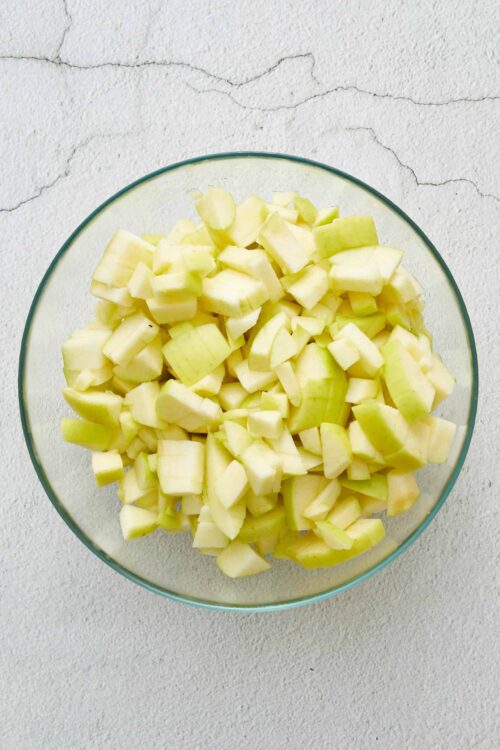 Chopped apple pieces in a glass bowl for baking or cooking recipes.
