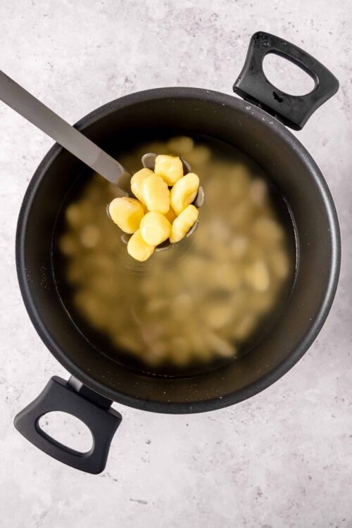 Butter and potato gnocchi boiling in a pot.