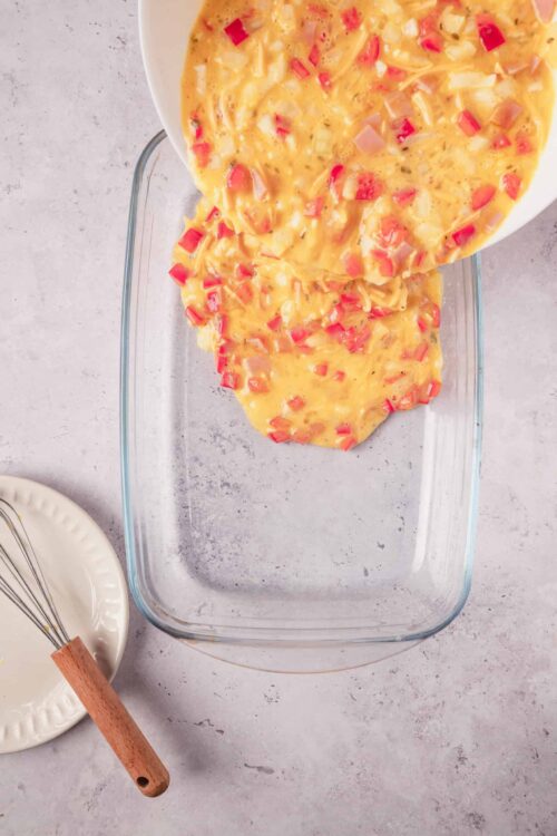 Creamy breakfast casserole with cheese and diced red peppers, ready for baking or serving.