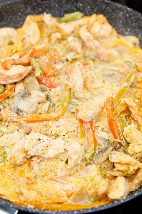 Creamy chicken and vegetable skillet with colorful peppers and herbs, perfect for comforting home-cooked meals.
