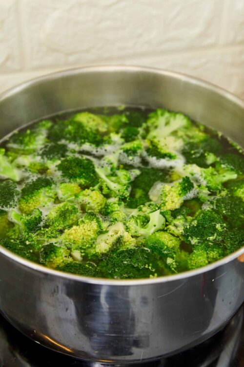 Steamed broccoli boiling in a stainless steel pot for healthy cooking.