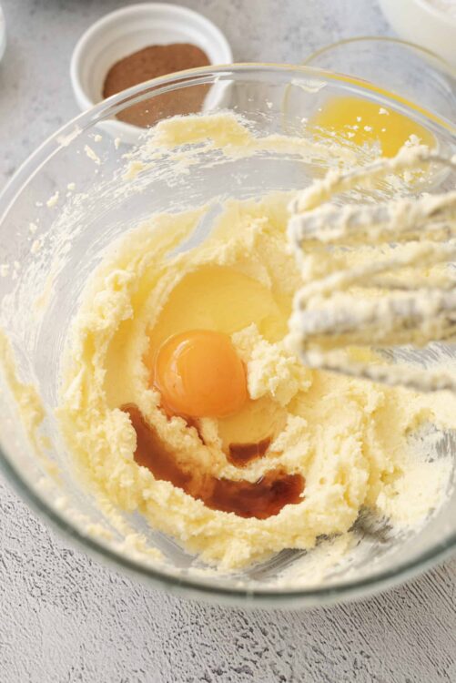 Creamy butter, sugar, and eggs in a glass mixing bowl for baking recipes.