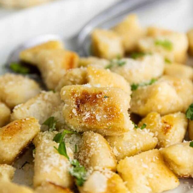 Creamy garlic parmesan gnocchi with herbs and melted cheese, perfect for cozy dinners.