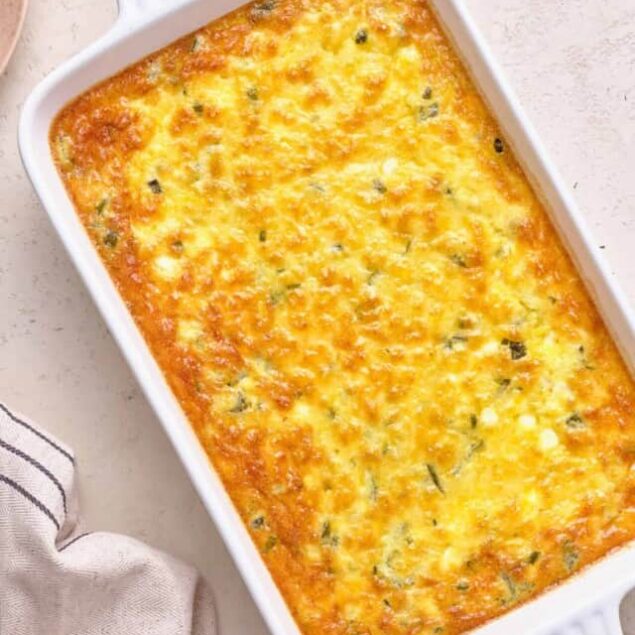 Creamy baked cheesy casserole with herbs in a white baking dish, ready to serve.