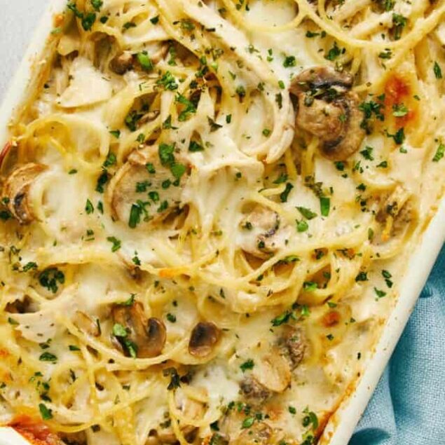 Creamy mushroom and chicken baked pasta dish with melted cheese and fresh herbs.