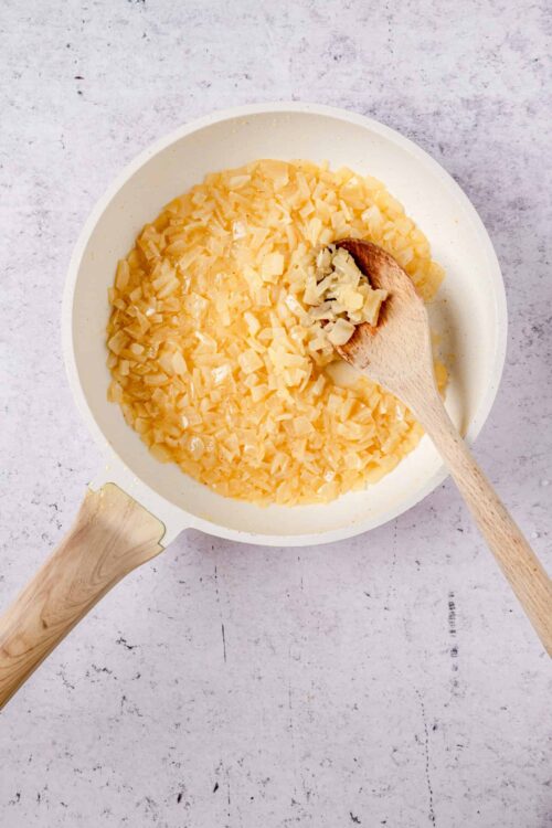 Creamy diced onions in a white skillet for cooking or sautéing.