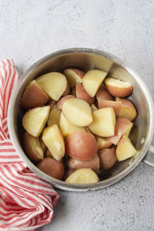 Sweet yellow and red potatoes in a stainless steel pot, ready for cooking or baking.