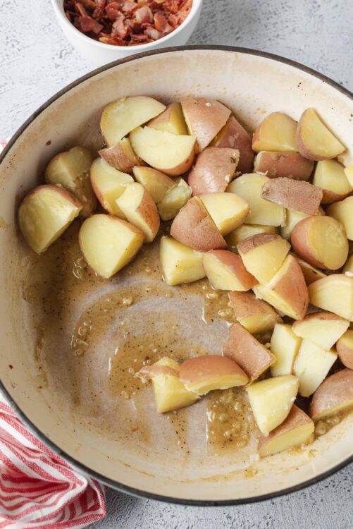 Baked Bree potato prep, seasoned potatoes cooking in a skillet for easy comfort food recipes.