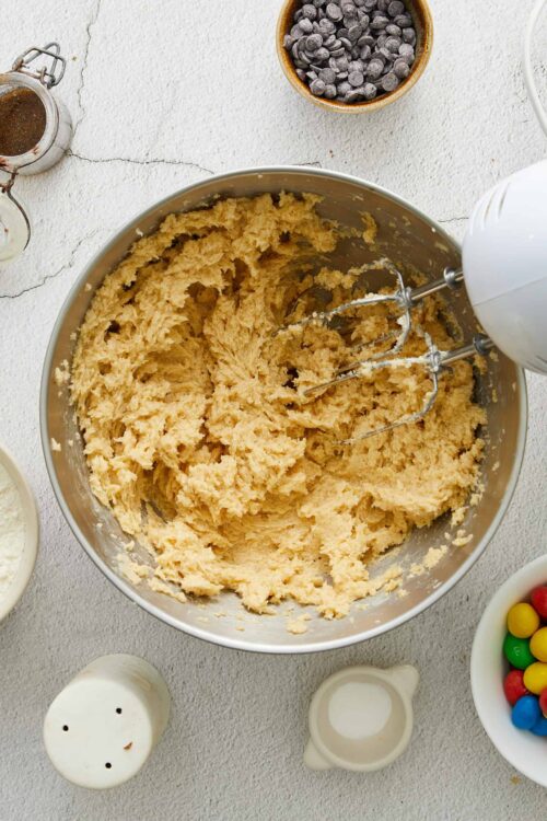 Creamy cookie dough being mixed in a stand mixer for baking recipes.