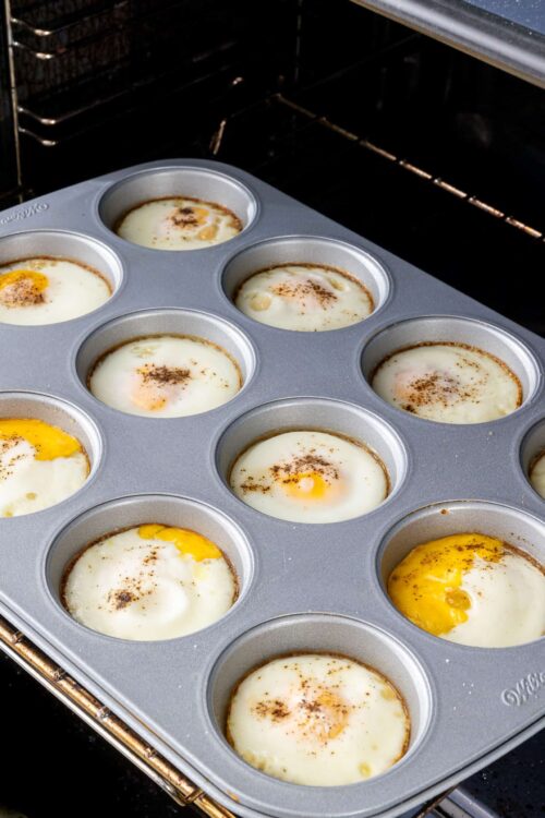 Soft-boiled eggs baking in a muffin tin in the oven.